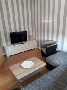 a living room with a tv and a coffee table at Specht-Ferienwohnung-1-Tangermuende in Tangermünde