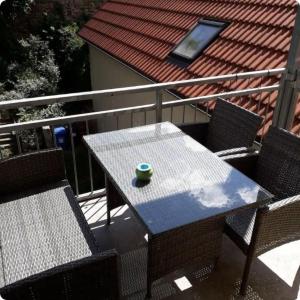a table and chairs on a balcony with a green cup on it at Specht-Ferienwohnung-1-Tangermuende in Tangermünde +2 photos