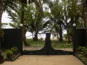 a black gate with trees in the background at Comfortable Studio with Sea View in Foulpointe - 30 m² in Foulpointe