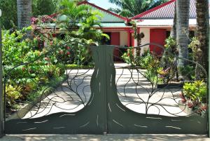 a gate in a garden with flowers and plants at Comfortable Studio with Sea View in Foulpointe - 30 m² in Foulpointe