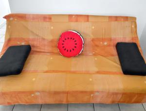 a wooden table with a red plate on it at Appartement convivial au Moule avec jardin clôturé in Le Moule