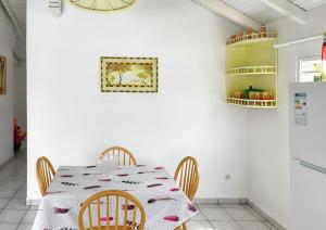 a dining room with a table and chairs at Appartement convivial au Moule avec jardin clôturé in Le Moule +14 photos