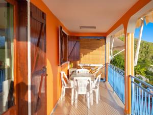 a balcony with a table and chairs on it at Appartement confortable avec vue sur mer à Bouillante, 50 m² in Bouillante