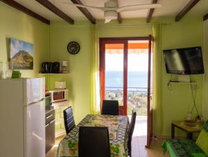 a kitchen with a table and a refrigerator and a window at Appartement confortable avec vue sur mer à Bouillante, 50 m² in Bouillante