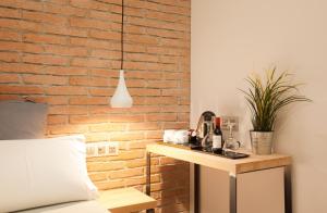 sypialnia z ceglaną ścianą i stołem w obiekcie Hostal Fernando w Barcelonie