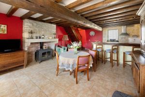 a kitchen and dining room with a table and a fireplace at Chez Pauline in Massangis