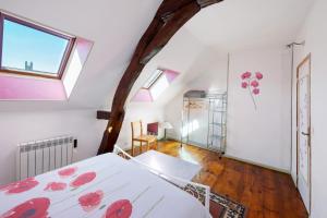 a bedroom with a bed with red flowers on it at Chez Pauline in Massangis