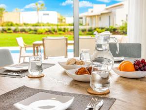 a table with bowls of fruit and a bottle of water at Villa Flamingo - BY SCH in Nadadouro