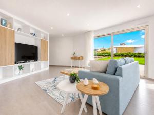 a living room with a blue couch and a table at Villa Flamingo - BY SCH in Nadadouro