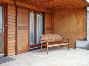 a wooden bench sitting on the porch of a house at Appartement cosy à Fayet avec vue in Fayet