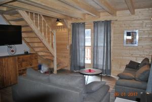 a living room with a couch and a tv at Chalet Enchanteur à Venosc avec Vue Panoramique et Jacuzzi in Vénosc +21 photos
