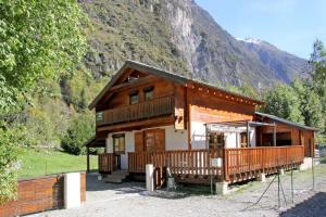 a log cabin with a mountain in the background at Chalet Enchanteur à Venosc avec Vue Panoramique et Jacuzzi in Vénosc