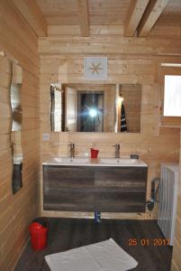 a bathroom with two sinks and a mirror at Chalet Enchanteur à Venosc avec Vue Panoramique et Jacuzzi in Vénosc