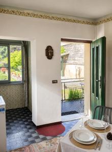a dining room with a table and a window at Lavanda Cozy Apartment near Lake Como and Lugano in Lanzo dʼIntelvi