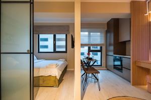 a bedroom and a kitchen with a bed and a table at Own the Moment by Blvd 41B7 - Free Parking in Voluntari