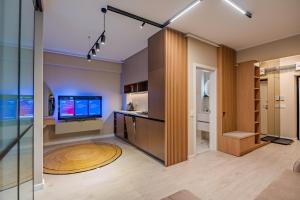 a living room with a tv and a glass wall at Own the Moment by Blvd 41B7 - Free Parking in Voluntari +49 photos