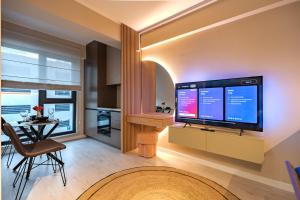 a living room with a large flat screen tv at Own the Moment by Blvd 41B7 - Free Parking in Voluntari