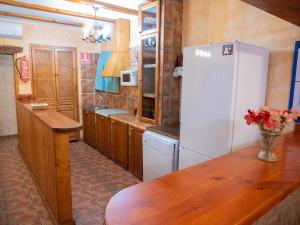 a kitchen with a white refrigerator and a wooden table at Elegant Villa in Archena + Private Pool in Archena