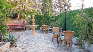 a patio with chairs and a fountain and a fence at Elegant Villa in Archena + Private Pool in Archena