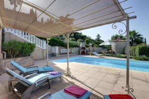 a patio with chairs and a swimming pool at Villa élégante à Fréjus, Piscine in Fréjus