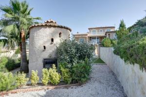 a house with a wall and a palm tree at Villa élégante à Fréjus, Piscine in Fréjus