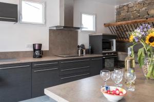 a kitchen with a table with wine glasses and a bowl of fruit at Maison avec piscine privée à La Digne-d'Aval in La Digne-dʼAval