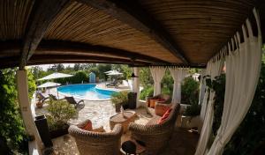 an outdoor patio with chairs and a swimming pool at Spacious Villa with Private Pool in Castellana Grotte in Alberobello