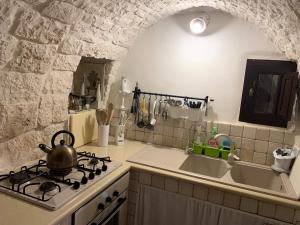 a kitchen with a stove with a tea kettle on it at Spacious Villa with Private Pool in Castellana Grotte in Alberobello