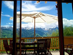a table with an umbrella on a deck with mountains at Chalet chaleureux à Ax-les-Thermes avec vue sur la montagne in Ax-les-Thermes