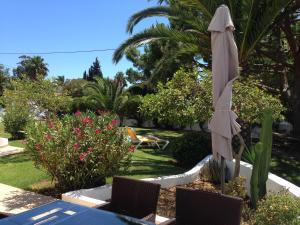 a white umbrella sitting on a table in a garden at Charming House in Carvoeiro + Pool in Carvoeiro