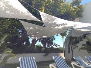 two chairs and a white umbrella in a yard at Charming House in Carvoeiro + Pool in Carvoeiro