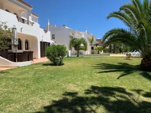 a yard of a house with green grass and palm trees at Charming House in Carvoeiro + Pool in Carvoeiro +48 photos