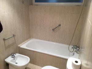 a bathroom with a tub and a toilet and a sink at Spacious Apartment in Terrassa with Shared Pool, 85 m² in Terrassa