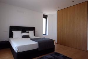 a bedroom with a large bed and a wooden cabinet at Luxurious Villa in Vieira do Minho – Private Pool in Vieira do Minho