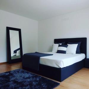 a bedroom with a large bed and a mirror at Luxurious Villa in Vieira do Minho – Private Pool in Vieira do Minho