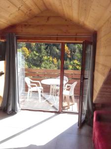 a patio with a table and chairs on a deck at Studio cosy à Saint-Jean-d'Arves 29 m² Vue montagne in Saint-Jean-dʼArves