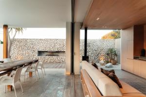 a living room with a stone wall at The Pool House in Gqeberha