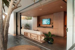 a bathroom with a tub and a tv on a wall at The Pool House in Gqeberha