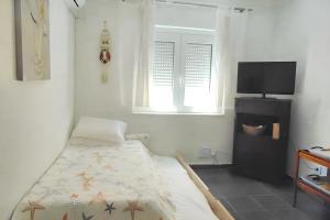 a bedroom with a bed and a flat screen tv at Bright apartment in Almada with shared pool in Almada