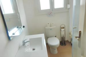 a white bathroom with a toilet and a sink at Bright apartment in Almada with shared pool in Almada