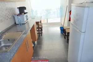 a kitchen with a sink and a refrigerator at Bright apartment in Almada with shared pool in Almada +19 photos