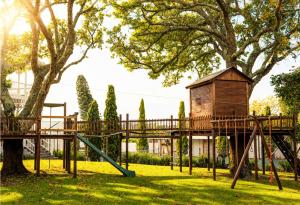a playground in a park with a tree at The Pool House in Gqeberha