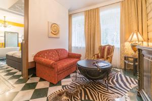 a living room with a red chair and a zebra rug at Comfortable apartment in Bad Schandau – 55 m² with garden terrace in Bad Schandau