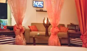 a living room with a couch and a candle at Studio confortable à Sainte-Anne 30 m² avec vue mer in Sainte-Anne