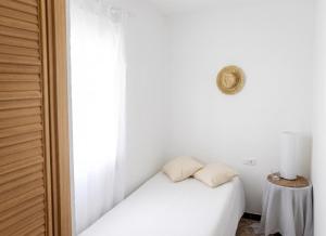 a white bedroom with a bed and a table at Charming House in El Chaparral in EL Chaparral