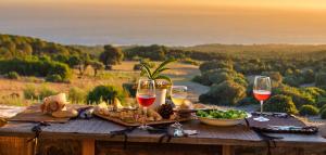a table with wine glasses and a plate of food at Charming House in El Chaparral in EL Chaparral +9 photos