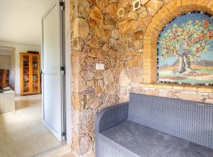 a stone wall with a bench in a room at Appartement confortable à Moltifao, vue sur montagne, 50 m² in Moltifao