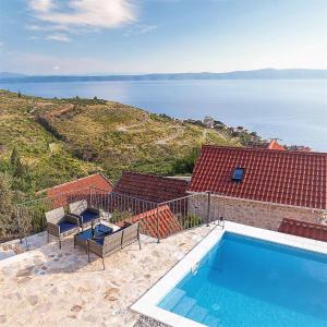 a house with a swimming pool and a view of the ocean at Elegant villa in Podgora with private pool and sea view in Podgora