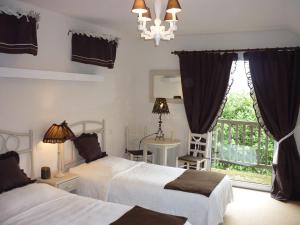 a bedroom with two beds and a balcony at Villa spacieuse à Haut-de-Bosdarros avec piscine privée in Haut-de-Bosdarros