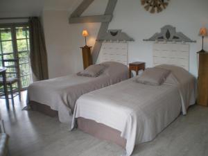 a bedroom with two beds and a table and chairs at Villa spacieuse à Haut-de-Bosdarros avec piscine privée in Haut-de-Bosdarros